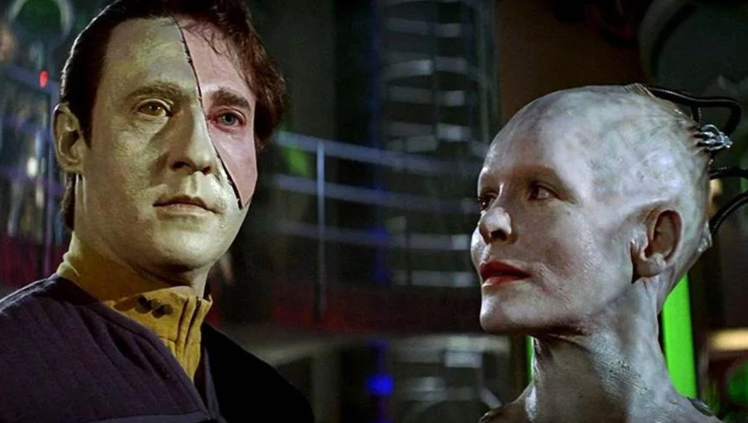 Data is half human and standing with the Borg Queen